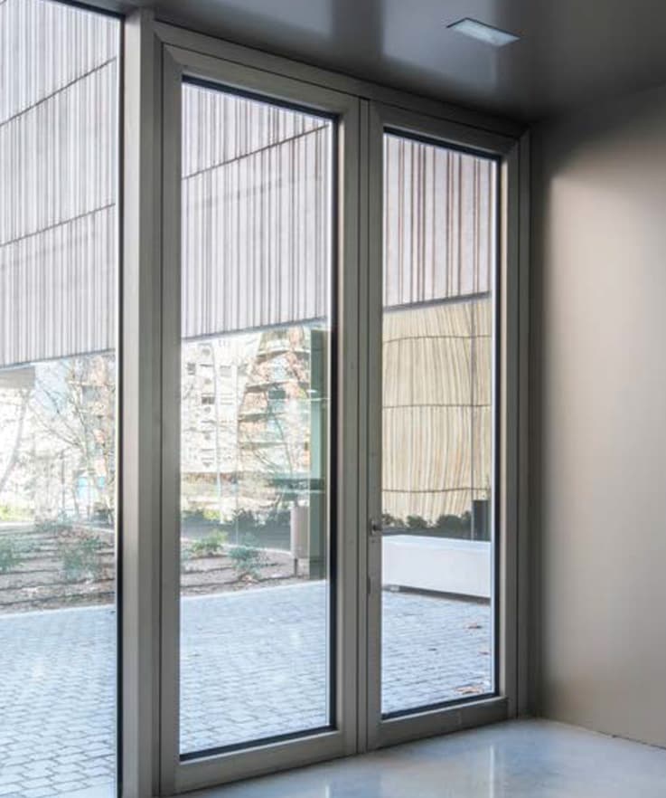 Porte d'entrée Cortizo Millennium Plus 70 en aluminium gris, double vantail vitré, intérieur architectural contemporain