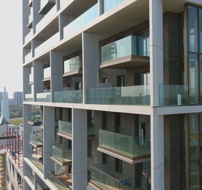 Garde-corps en verre View Crystal sur les balcons d'un immeuble résidentiel contemporain en brique