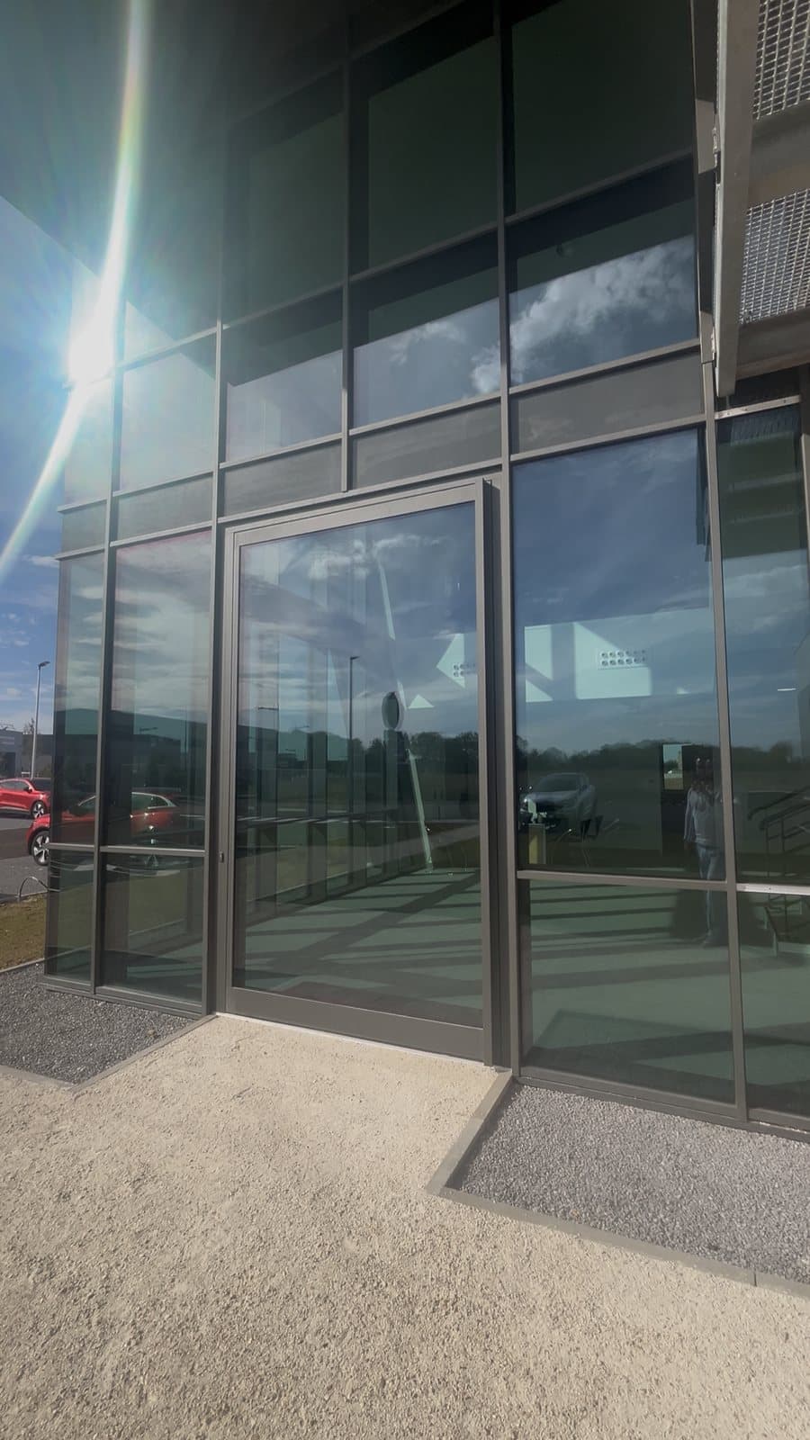 Façade extérieure du siège MAC : mur rideau Reynaers SlimWall 35 et porte d'entrée