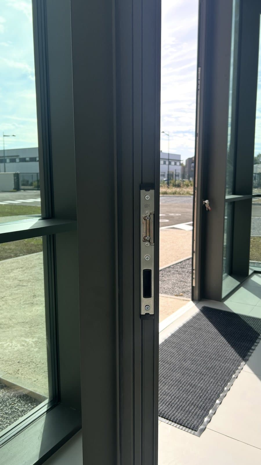 Détail de la gâche électrique intégrée au dormant de la porte pivot