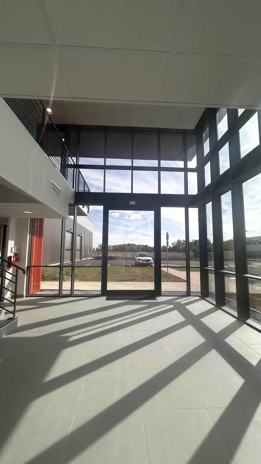 Hall d'accueil du siège MAC : mur rideau Reynaers SlimWall 35 sur double hauteur