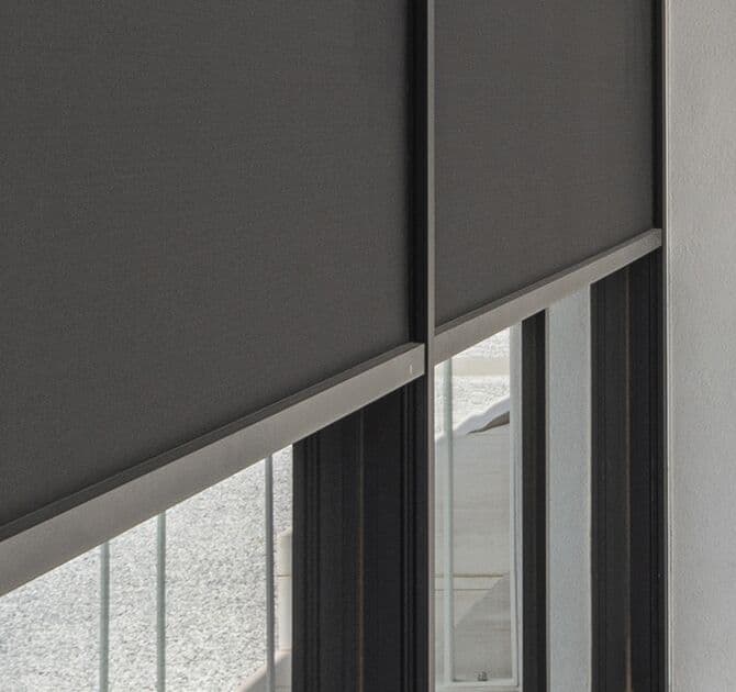 Façade mur-rideau Reynaers CW 50 équipée de stores screen extérieurs de protection solaire sur les vitrages