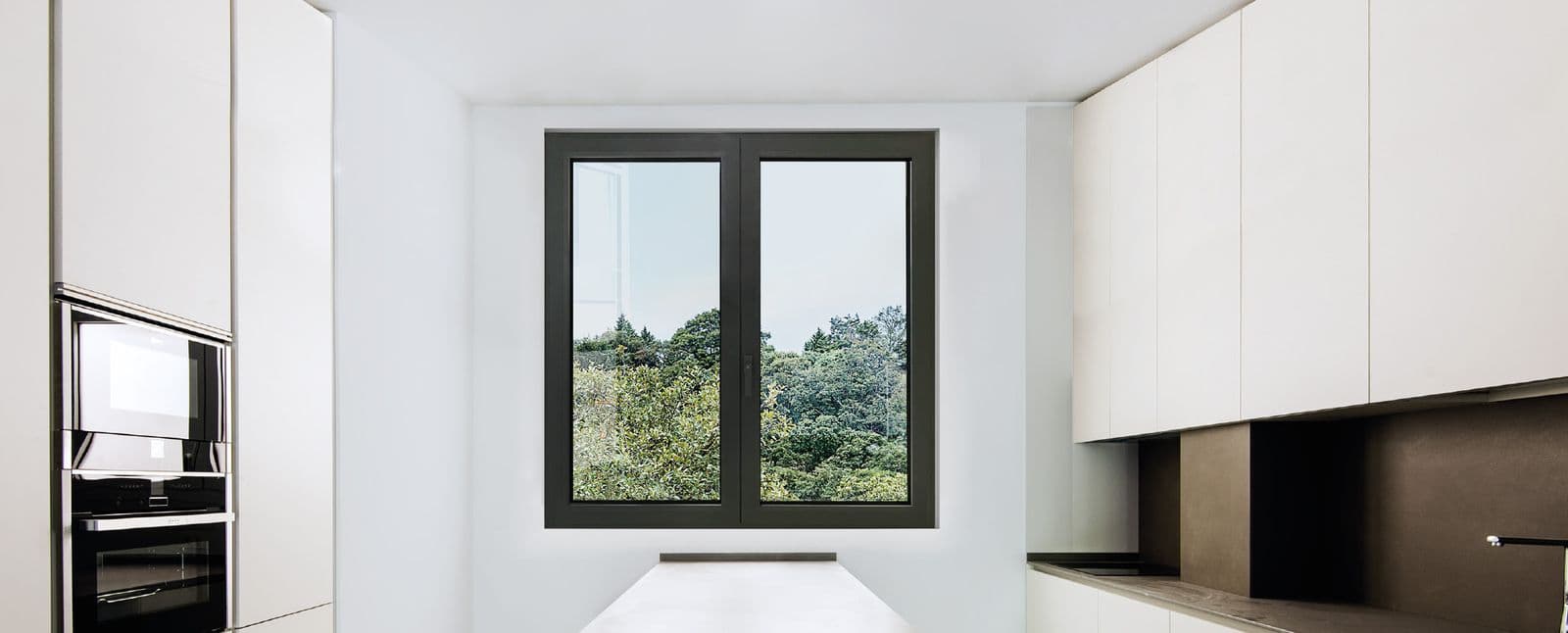 Fenêtre aluminium noire sur mesure dans une cuisine contemporaine, avec vue sur la verdure